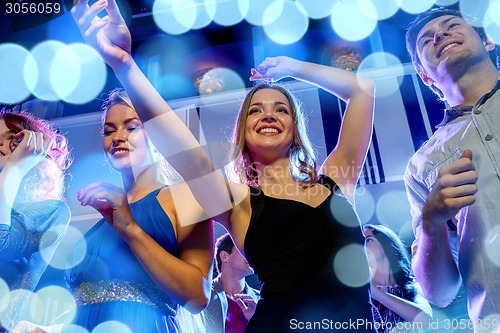 Image of smiling friends dancing in club
