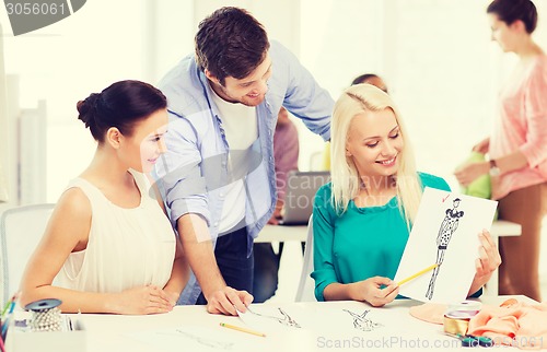 Image of smiling fashion designers working in office