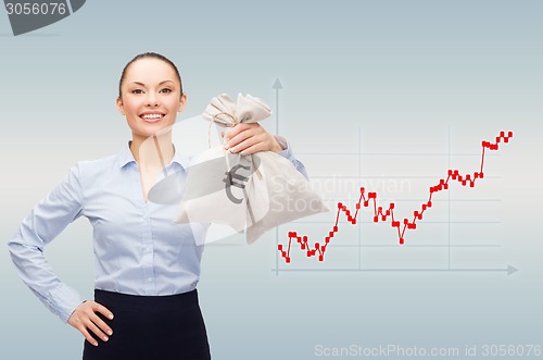 Image of happy businesswoman holding money bags with dollar