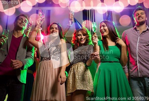 Image of smiling friends with glasses of champagne in club