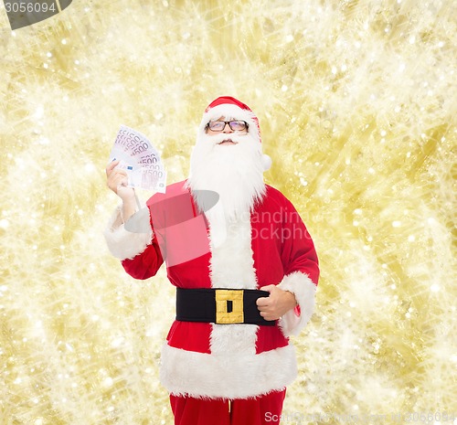 Image of man in costume of santa claus with euro money