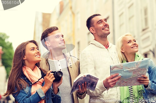 Image of group of friends with city guide, map and camera