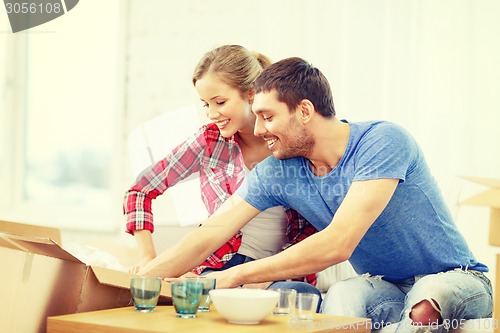 Image of smiling couple unpacking kitchenwear