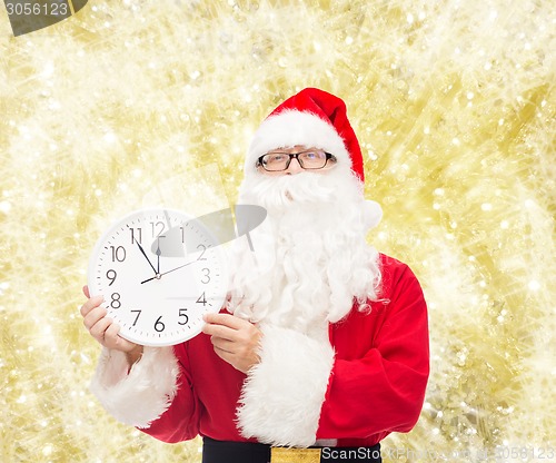 Image of man in costume of santa claus with clock