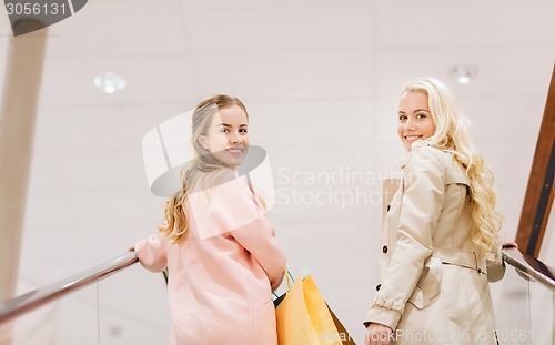 Image of happy young women with shopping bags in mall