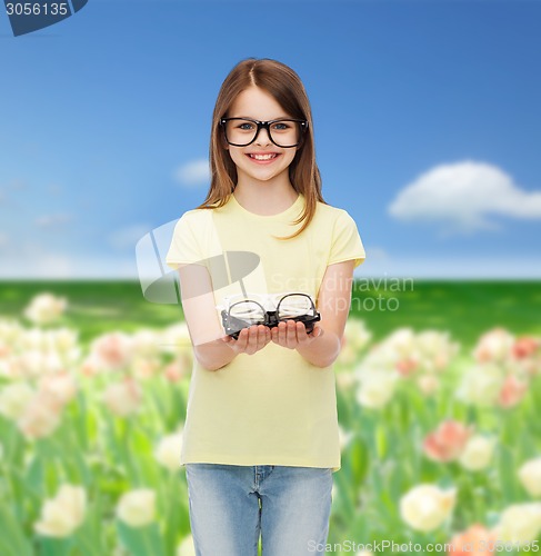 Image of smiling cute little girl in black eyeglasses