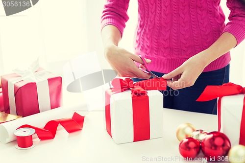 Image of close up of woman decorating christmas presents