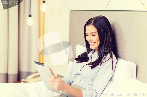 Image of happy businesswoman with tablet pc in hotel room