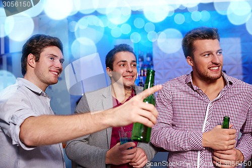 Image of group of male friends with beer in nightclub