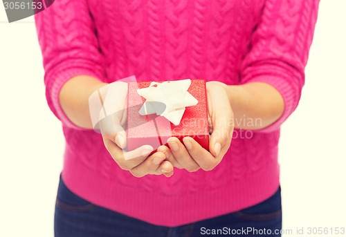 Image of close up of woman in pink sweater holding gift box