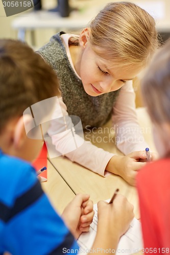 Image of group of students talking and writing at school