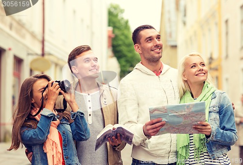 Image of group of friends with city guide, map and camera