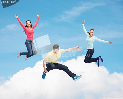 Image of group of smiling teenagers jumping in air