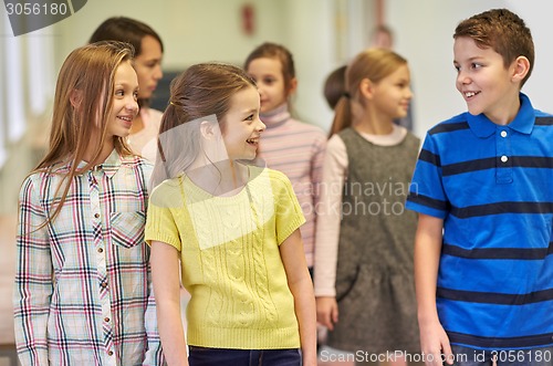 Image of group of smiling school kids walking in corridor