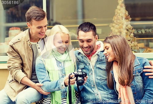 Image of group of smiling friends with digital photocamera