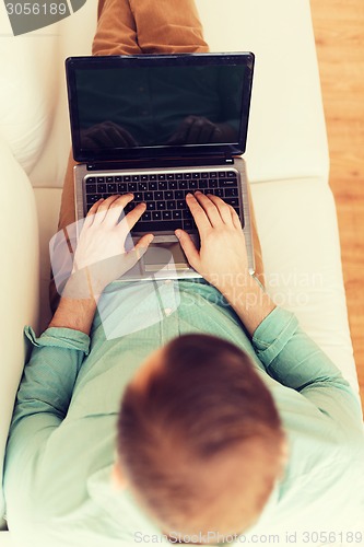 Image of close up of man working with laptop at home