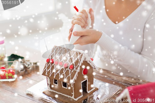 Image of close up of woman making gingerbread house at home