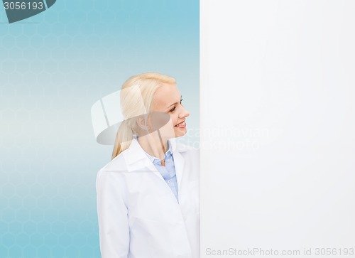 Image of smiling female doctor with white blank board