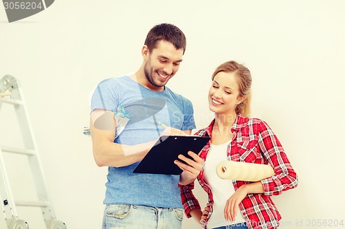 Image of smiling couple with clipboard and wallpaper roll