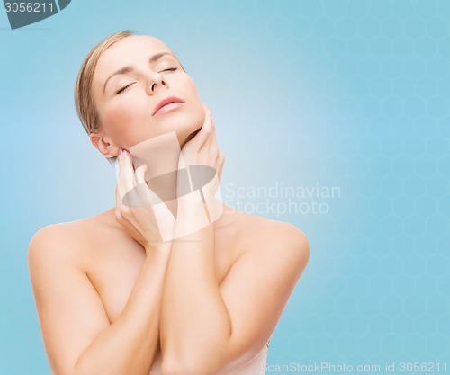 Image of beautiful young woman touching her neck