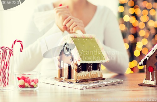 Image of close up of woman making gingerbread houses