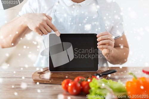 Image of closeup of man showing tablet pc screen in kitchen