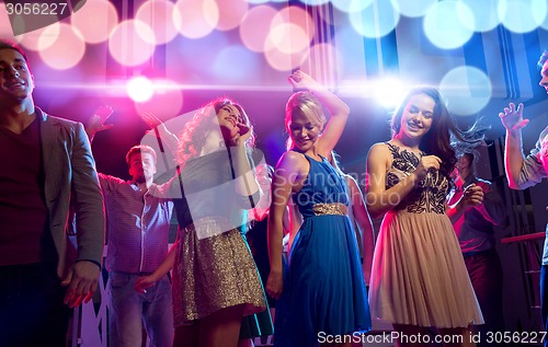 Image of smiling friends dancing in club