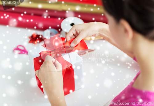 Image of close up of woman decorating christmas present