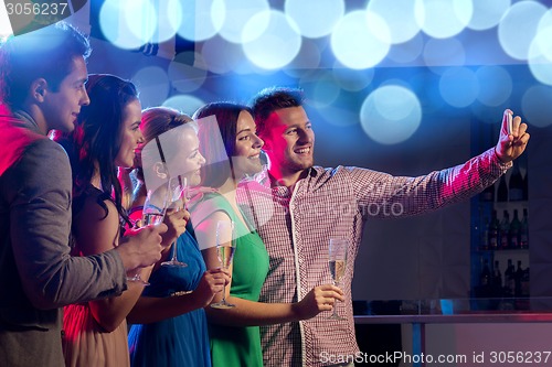 Image of friends with glasses and smartphone in club