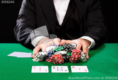 Image of poker player with cards and chips at casino