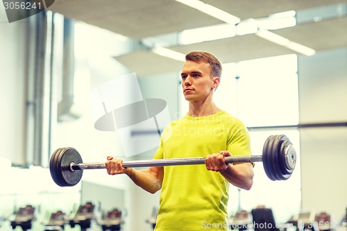 Image of man doing exercise with barbell in gym