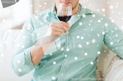 Image of close up of man drinking red wine at home