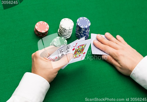 Image of poker player with cards and chips at casino