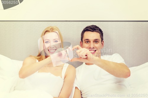 Image of smiling couple showing heart with hands