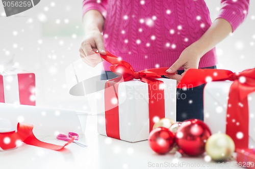 Image of close up of woman decorating christmas presents