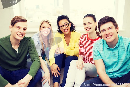 Image of five smiling teenagers having fun at home