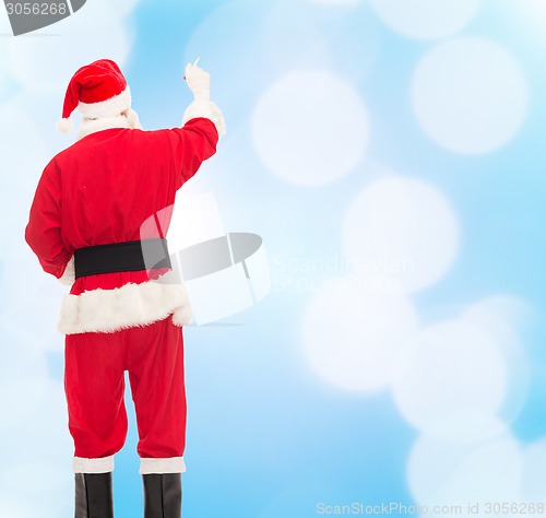 Image of man in costume of santa claus writing something