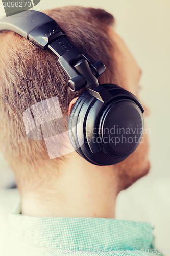 Image of close up of man in headphones at home