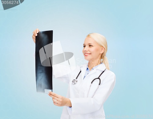 Image of smiling female doctor looking at x-ray image