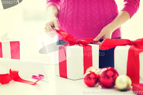 Image of close up of woman decorating christmas presents