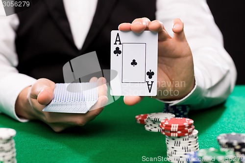 Image of holdem dealer with playing cards and casino chips