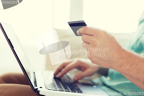 Image of close up of man with laptop and credit card