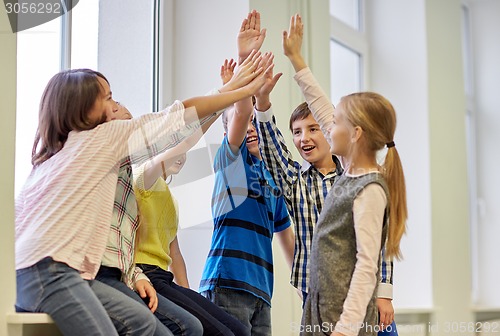 Image of group of smiling school kids making high five