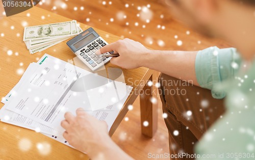 Image of close up of man counting money and making notes