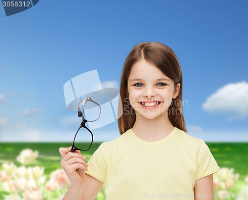 Image of smiling cute little girl holding black eyeglasses