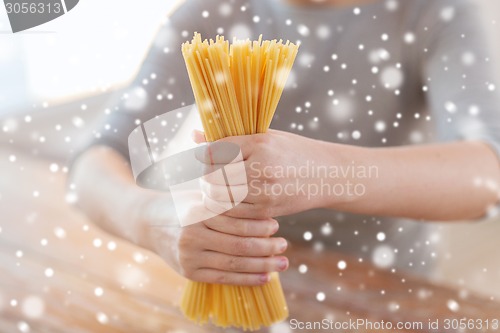 Image of close up of female hands holding spaghetti pasta