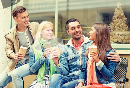 Image of group of smiling friends with take away coffee