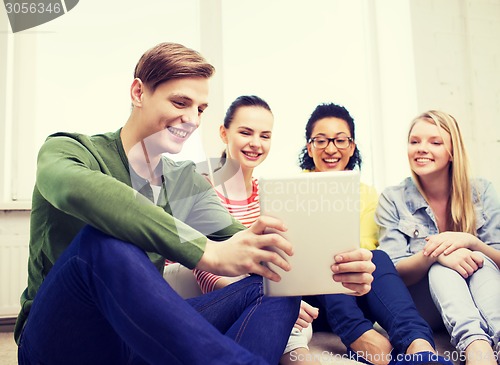 Image of smiling students making picture with tablet pc