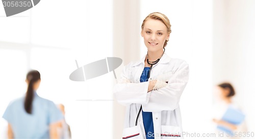 Image of smiling young female doctor in white coat