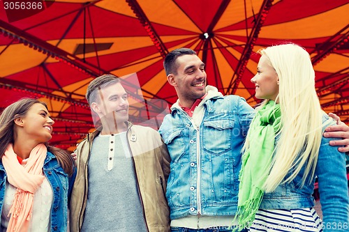 Image of group of smiling friends in amusement park